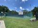 Community tennis court with green fencing and lighting at 164 Royal Palm Dr, Leesburg, FL 34748