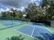 Community tennis courts with blue surface, green perimeter, surrounded by a green fence at 164 Royal Palm Dr, Leesburg, FL 34748