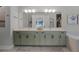 Bright bathroom with a double vanity, large mirrors, and sage green cabinets at 17290 Hickory Wind Dr, Clermont, FL 34711
