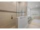 Modern bathroom features a glass-enclosed shower, decorative tile work and neutral color palette at 17290 Hickory Wind Dr, Clermont, FL 34711