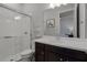 Bright bathroom with a glass-enclosed shower, dark wood vanity, and a large mirror at 17290 Hickory Wind Dr, Clermont, FL 34711