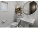 Cozy powder room featuring a pedestal sink, decorative mirror, and charming decor at 17290 Hickory Wind Dr, Clermont, FL 34711