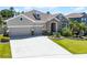 Inviting home showcasing a manicured lawn, mature landscaping, and a convenient three-car garage at 17290 Hickory Wind Dr, Clermont, FL 34711