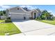 Charming single-Gathering home featuring a well-maintained lawn and a spacious driveway leading to a three-car garage at 17290 Hickory Wind Dr, Clermont, FL 34711