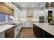 Modern kitchen features white cabinets, a stainless steel farmhouse sink, and a spacious island at 17290 Hickory Wind Dr, Clermont, FL 34711