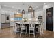 Open kitchen with a large center island, pendant lighting, stainless appliances, and seating for six at 17290 Hickory Wind Dr, Clermont, FL 34711