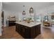 Open kitchen features a center island with barstool seating, stainless appliances and hardwood floors at 17290 Hickory Wind Dr, Clermont, FL 34711
