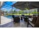Covered patio featuring a seating area with comfortable wicker furniture and a serene view of the backyard at 17290 Hickory Wind Dr, Clermont, FL 34711