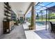 Spacious patio with stylish furniture and decor overlooking the lush backyard and screened-in pool area at 17290 Hickory Wind Dr, Clermont, FL 34711