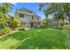 Large backyard with a lush lawn, mature trees, a covered patio, and meticulous landscaping at 1785 Rushden Dr, Ocoee, FL 34761