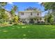 Sprawling backyard with manicured lawn, mature trees, a covered patio, and meticulous landscaping at 1785 Rushden Dr, Ocoee, FL 34761