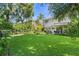 Expansive backyard featuring mature shade trees, lush lawn, a covered patio and landscaping at 1785 Rushden Dr, Ocoee, FL 34761