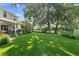 Expansive backyard featuring mature shade trees and a covered patio area at 1785 Rushden Dr, Ocoee, FL 34761