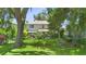 View of the home's backyard with lush greenery, mature trees, and a black fence at 1785 Rushden Dr, Ocoee, FL 34761