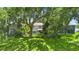 Spacious backyard with a view of the house, mature trees, and black fence at 1785 Rushden Dr, Ocoee, FL 34761