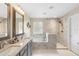 Modern bathroom featuring dual sinks, marble counters, a soaking tub, and walk-in shower at 1785 Rushden Dr, Ocoee, FL 34761