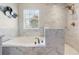 Bathroom features a marble tiled soaking tub and shower with a bronze showerhead at 1785 Rushden Dr, Ocoee, FL 34761