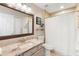 Bright bathroom featuring a granite vanity top, tile flooring, and a shower with a white shower curtain at 1785 Rushden Dr, Ocoee, FL 34761