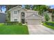 Traditional two-story home with a well-manicured lawn, beautiful landscaping, and an attached two-car garage at 1785 Rushden Dr, Ocoee, FL 34761