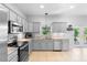 Kitchen boasts stainless steel appliances, light gray cabinets, and backyard views at 1785 Rushden Dr, Ocoee, FL 34761