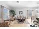 Spacious living room with a cozy seating area, complemented by natural light and elegant decor, seamlessly flowing into the dining area at 1785 Rushden Dr, Ocoee, FL 34761