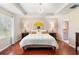 Bright bedroom with hardwood floors, a tray ceiling, and en-suite bathroom access at 1785 Rushden Dr, Ocoee, FL 34761