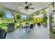 Relaxing covered outdoor patio with ceiling fan, BBQ, and a dining area overlooking the landscaped backyard at 1785 Rushden Dr, Ocoee, FL 34761
