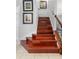 Elegant staircase with hardwood steps, complemented by wrought iron spindles and a wooden handrail at 1785 Rushden Dr, Ocoee, FL 34761