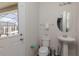 Half bathroom with pedestal sink, modern toilet, and a door leading to the lanai at 1811 Caribbean View Ter, Kissimmee, FL 34747