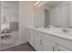 Bathroom with double vanity, white countertops, and a mirror reflecting into a bedroom with pink and white walls at 1811 Caribbean View Ter, Kissimmee, FL 34747