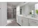 Bright bathroom with a glass-enclosed shower, single sink vanity with a white countertop, and a large mirror at 1811 Caribbean View Ter, Kissimmee, FL 34747