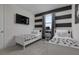 Charming bedroom featuring twin beds, black and white accents, and a wall-mounted TV at 1811 Caribbean View Ter, Kissimmee, FL 34747