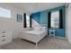 Stylish bedroom featuring a blue accent wall, white furniture, and natural light from windows with black curtains at 1811 Caribbean View Ter, Kissimmee, FL 34747