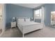 Comfortable bedroom with a queen bed, light blue accent wall, and a window with natural light at 1811 Caribbean View Ter, Kissimmee, FL 34747