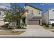 Modern two-story home with stone accents, a two-car garage, and manicured landscaping at 1811 Caribbean View Ter, Kissimmee, FL 34747