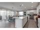 Modern kitchen and dining area with a center island, stainless steel appliances, and bright lighting at 1811 Caribbean View Ter, Kissimmee, FL 34747