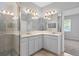 Well-lit bathroom featuring double sinks, quartz countertops, a walk-in shower with glass door at 1841 Overcup Ave, St Cloud, FL 34769