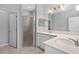 Bathroom featuring double sinks, quartz countertops, walk-in shower with glass door, and neutral decor at 1841 Overcup Ave, St Cloud, FL 34769