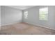 Bright bedroom with two windows providing natural light, neutral walls, and soft carpeting at 1841 Overcup Ave, St Cloud, FL 34769