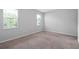 An empty bedroom with neutral walls, carpet and trim with two windows bringing in natural light at 1841 Overcup Ave, St Cloud, FL 34769