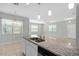 Open kitchen with granite countertops, stainless steel sink, and a view into the living area at 1841 Overcup Ave, St Cloud, FL 34769