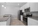 Contemporary kitchen with stainless steel appliances, granite countertops, white cabinetry and tile floor at 1841 Overcup Ave, St Cloud, FL 34769