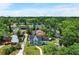Aerial view of a blue two-story home surrounded by lush greenery in a residential neighborhood at 201 Garden Ln, Longwood, FL 32750