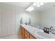 Bright bathroom featuring dual sinks, a large mirror, wood cabinets, and ample counter space at 201 Garden Ln, Longwood, FL 32750