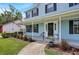 Inviting front porch with white columns, dark shutters, and manicured landscaping at 201 Garden Ln, Longwood, FL 32750
