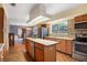 Bright kitchen features wood cabinets, butcher block island, stainless steel appliances, and mosaic tile backsplash at 201 Garden Ln, Longwood, FL 32750