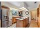 Bright kitchen featuring stainless steel refrigerator, center island with sink, and ample cabinetry at 201 Garden Ln, Longwood, FL 32750