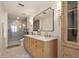 Modern bathroom featuring double sinks, walk-in shower, and decorative sconces at 2036 Brink Aly, Orlando, FL 32814
