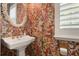 Unique bathroom features bright wallpaper and a pedestal sink with gold fixtures at 2036 Brink Aly, Orlando, FL 32814