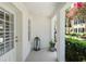 Inviting entry with white door, lantern, potted plant, and a glimpse of the landscaped community at 2036 Brink Aly, Orlando, FL 32814